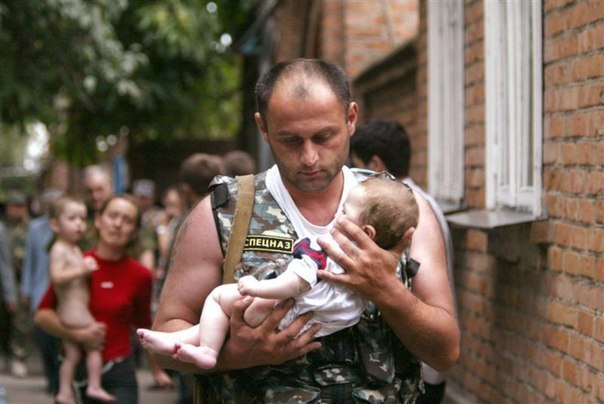 Российский спецназовец несет ребенка 